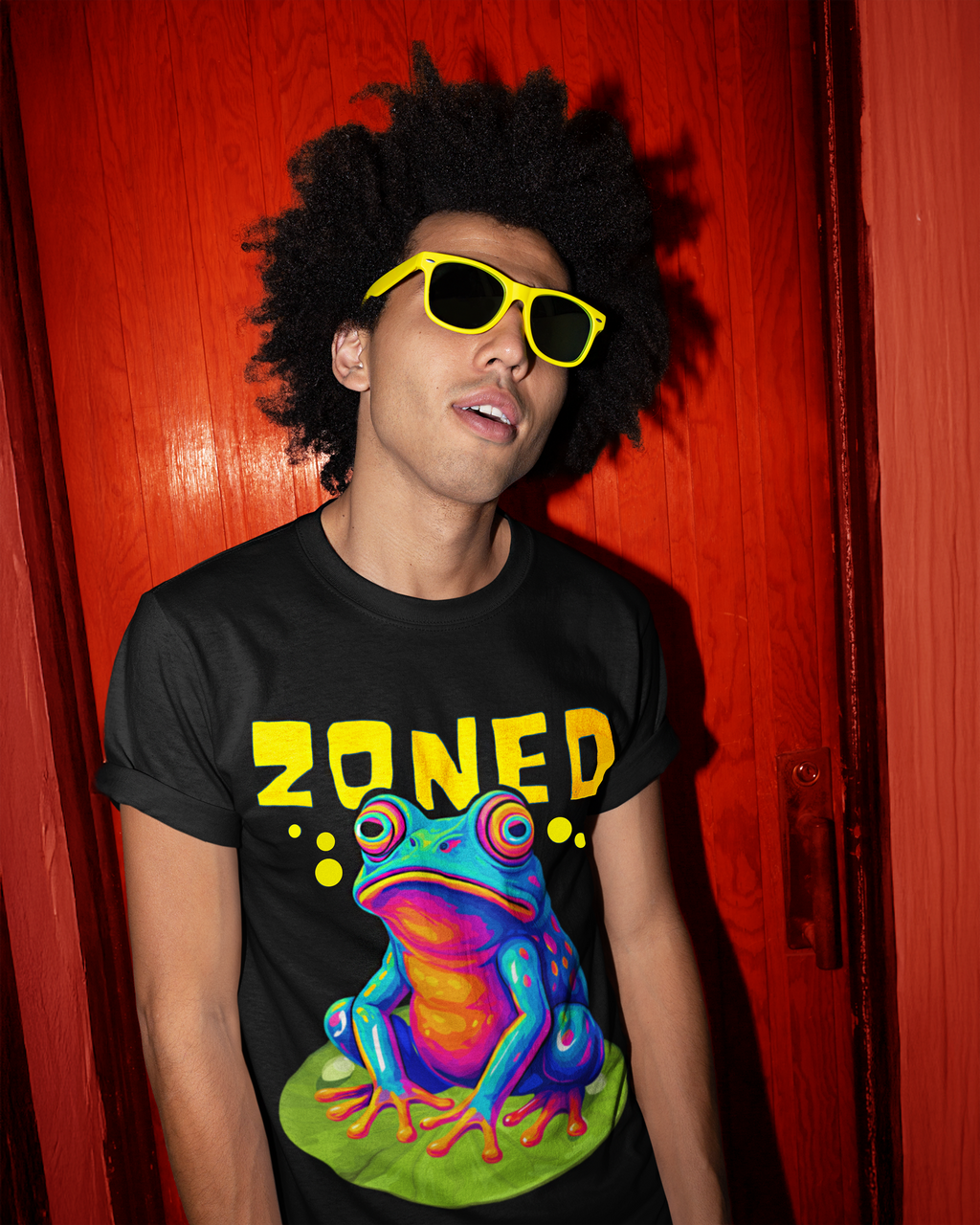 Model wearing ZONED psychedelic frog oversized t-shirt by LMNO streetwear, with sunglasses against an orange background